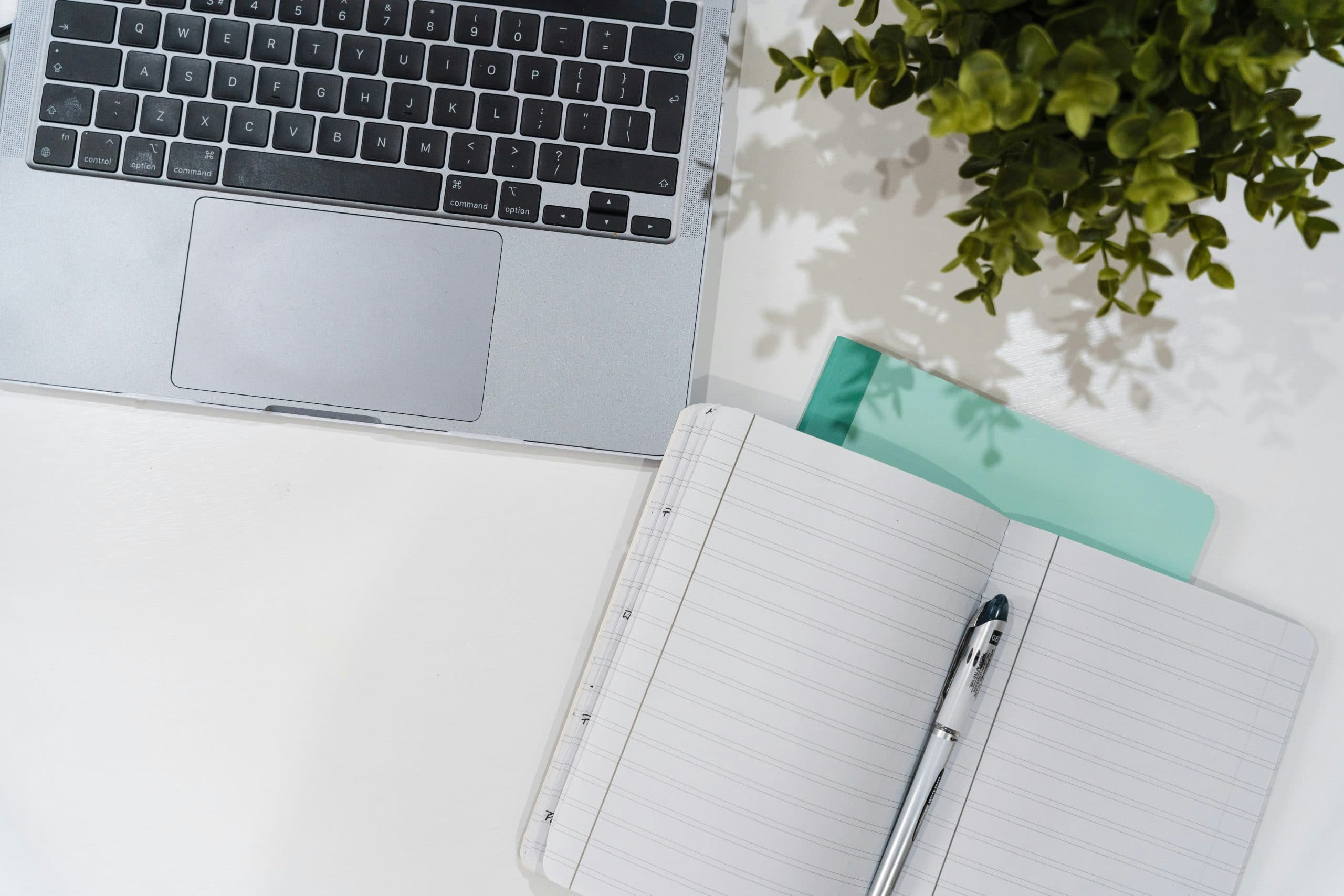 Laptop, notebook, and pen on a desk